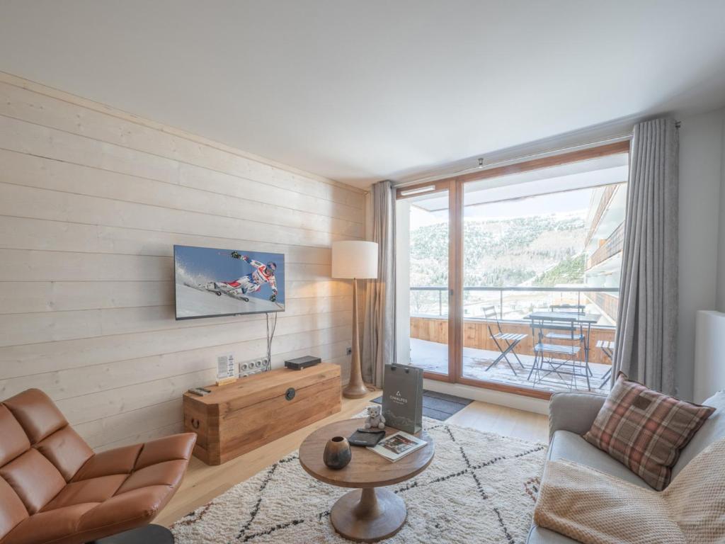 a living room with a couch and a table at Appartement 2 pièces - Centre Vieil Alpe, parking inclus - FR-1-645-59 in LʼHuez
