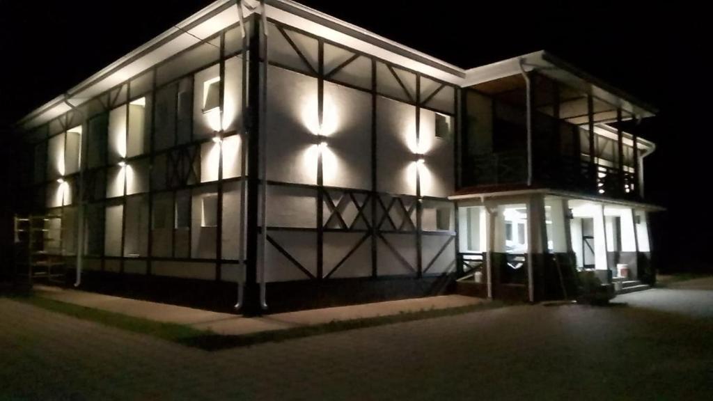een groot gebouw met 's nachts verlichting bij гостиница Мюнхен in Shcherbakovo