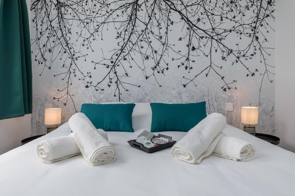 un lit blanc avec trois oreillers et une fresque d'arbre dans l'établissement L'escale normande - Terrasse - Gare, à Rouen