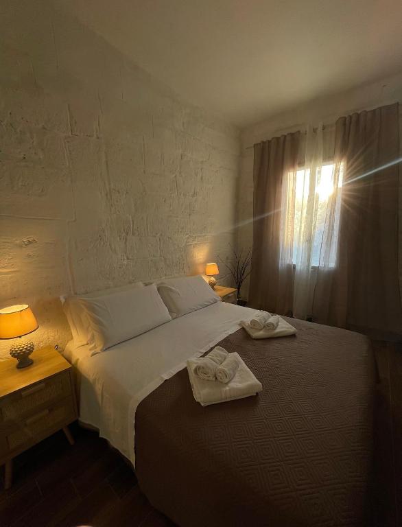 a bedroom with a bed with two towels on it at Casa Buena Vida (locazione ad uso turistico) in Monopoli