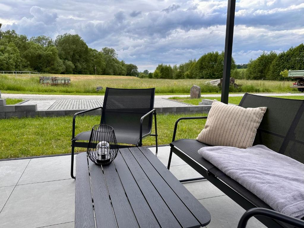 a patio with a wooden bench and a chair at Ferienwohnung Storchennest in Eisfeld