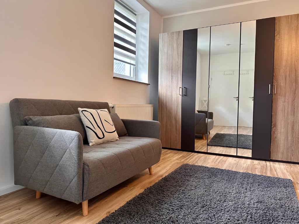 a living room with a couch and a mirror at Ferienwohnung Storchennest in Eisfeld