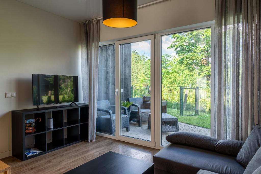 uma sala de estar com uma porta de vidro deslizante em Weekend apartment em Sigulda