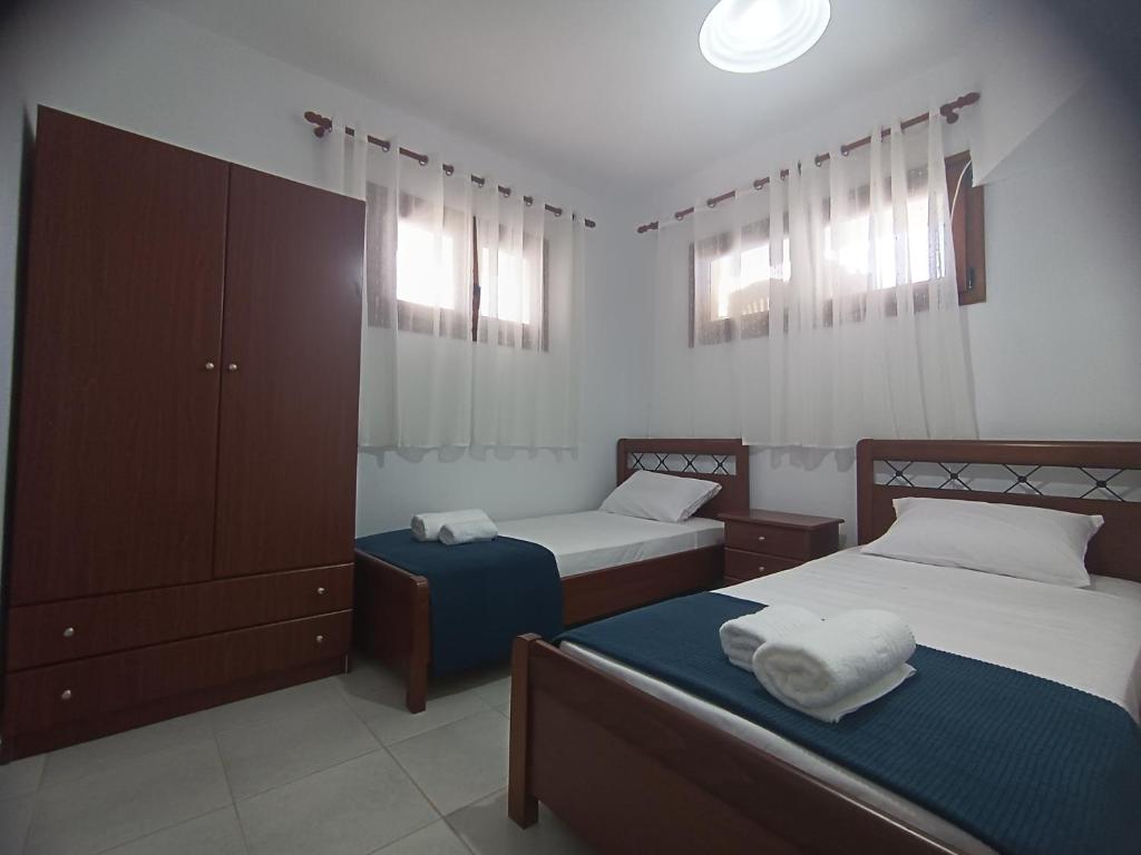 a bedroom with two beds and a dresser in it at Vacation House Rental 20m From the Beach in Gerakini