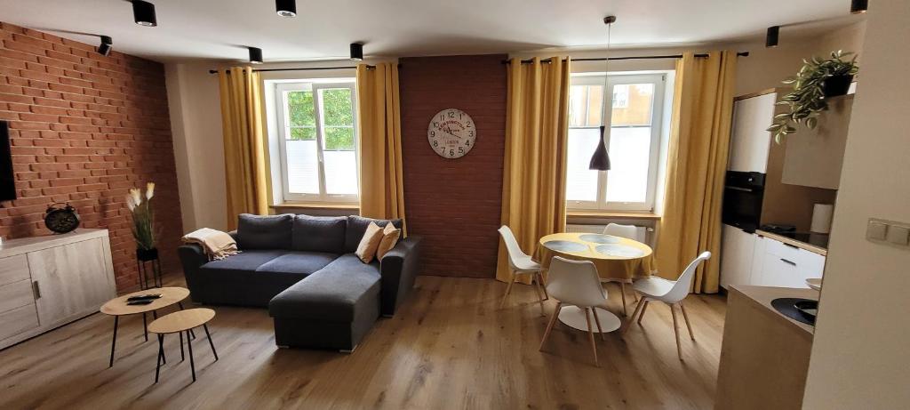 ein Wohnzimmer mit Sofa und Tisch in der Unterkunft Gold Apartament in Olsztyn