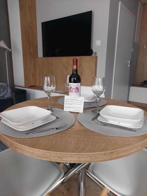 uma mesa com uma garrafa de vinho e dois copos em Apartament Śnieżka em Karpacz