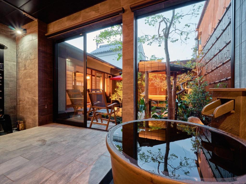eine Terrasse mit großem Fenster und einem Fischteich in der Unterkunft Konjakuso Nara Naramachi Steam Bath House - Vacation STAY 93298v in Nara