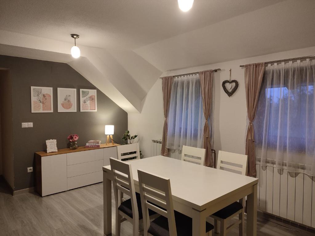 comedor con mesa blanca y sillas en Apartment Lana en Rakovica