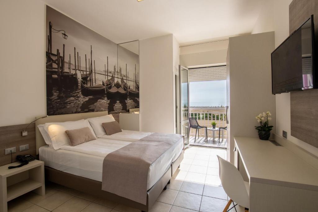 a bedroom with a large bed and a balcony at Hotel Lux in Caorle