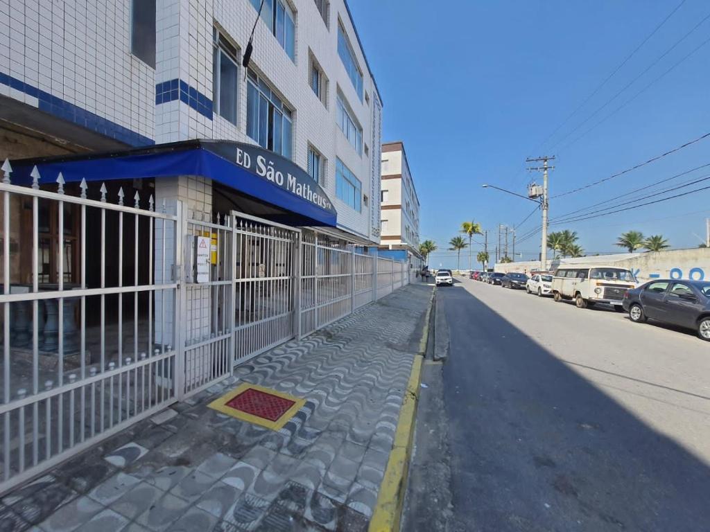 プライア・グランデにあるBEIRA MAR I - TUPI - 15 metros da praia - 2 dormitórios com VARANDA - WI FI e acomoda até 8 pessoas - ESTACIONAMENTO Gratuitoの通り側の柵付き建物