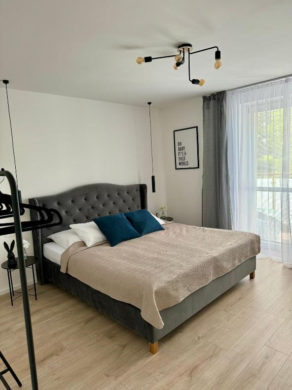 a bedroom with a large bed with blue pillows at Apartment ZANzi in Šamorín