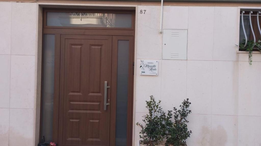 a brown door to a building with a window at Dimora Moscato Reale in Trani