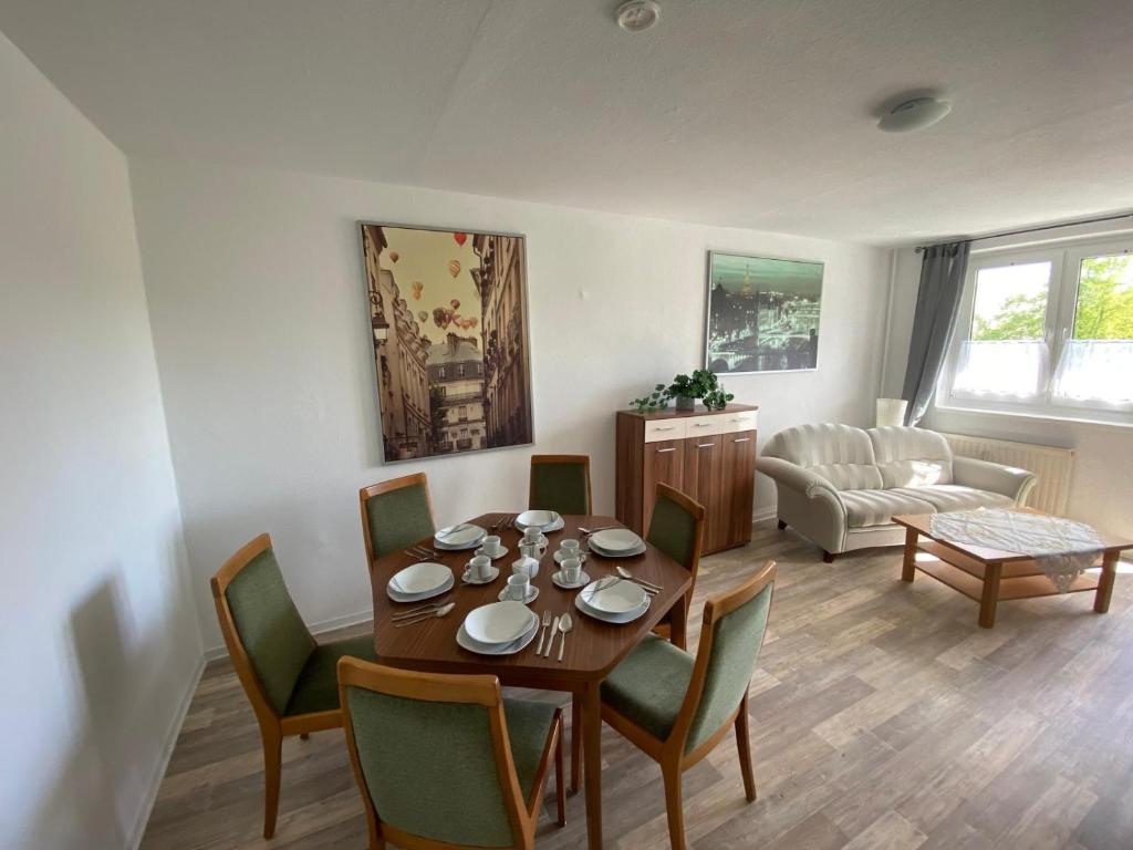 a living room with a table and chairs and a couch at Neue Ferien Monteurwohnung mit 3 Schlafzimmer 22 in Wefensleben