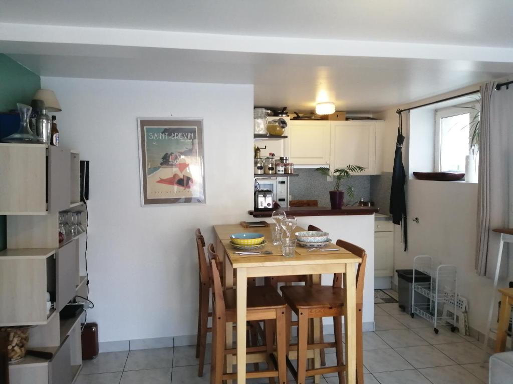 une cuisine avec une table et des chaises dans une pièce dans l'établissement T3 centre et plage, à Saint-Brévin-les-Pins
