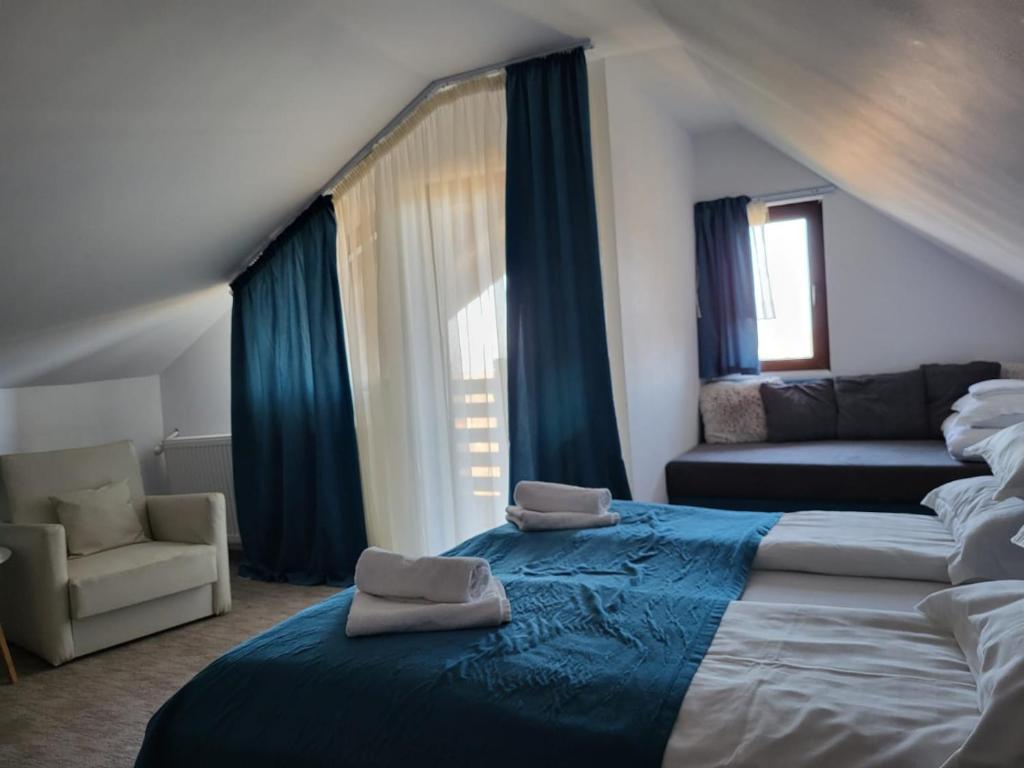 a bedroom with a large bed and a couch at Pensiunea La Voicut in Sohodol