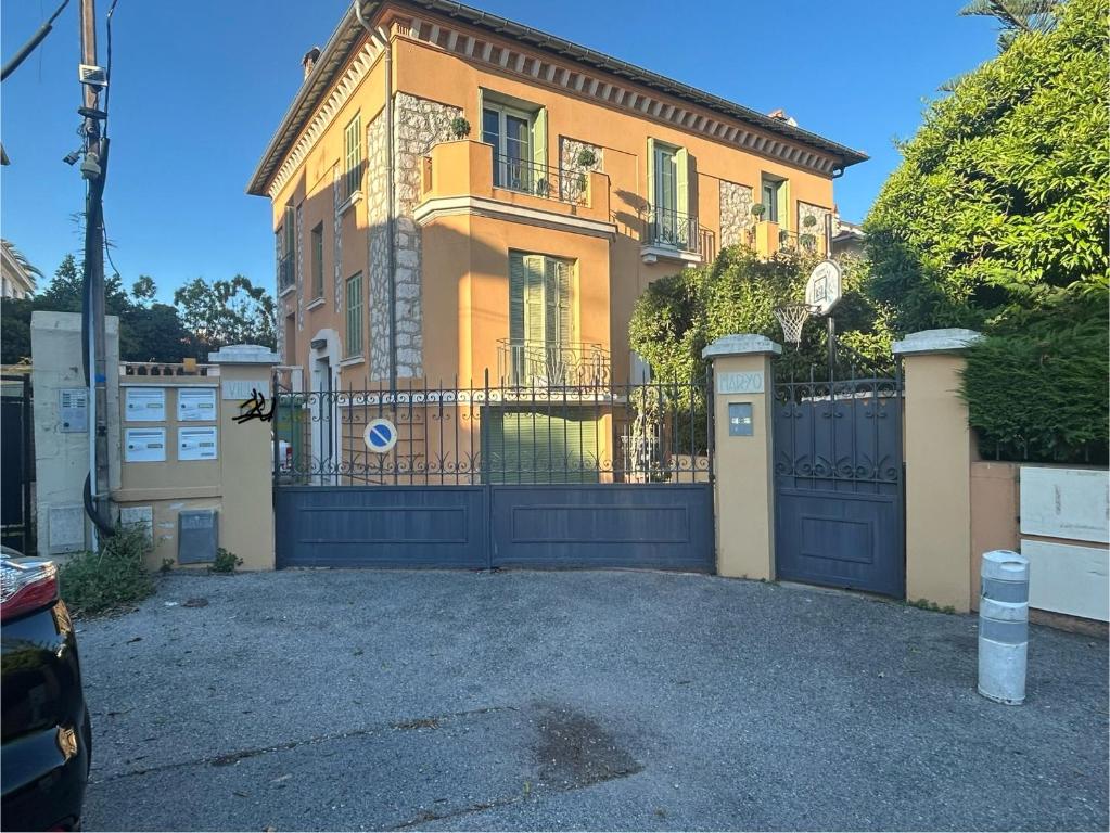 une grande maison avec un portail et une allée. dans l'établissement T3 dans une villa près de la mer, à Nice