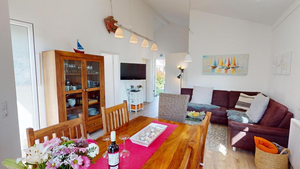 a living room with a table and a couch at Feriendorf Südstrand Haus 23 in Pelzerhaken