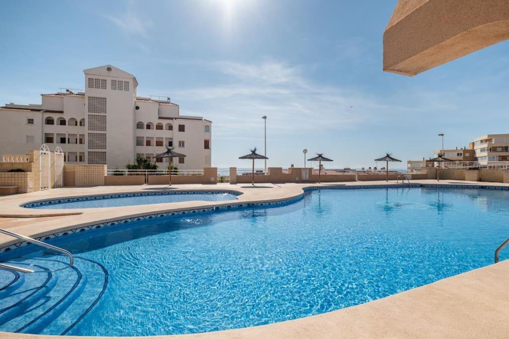 una grande piscina con acqua blu in un edificio di Bungalow Barlovento Playa ad Arenales del Sol