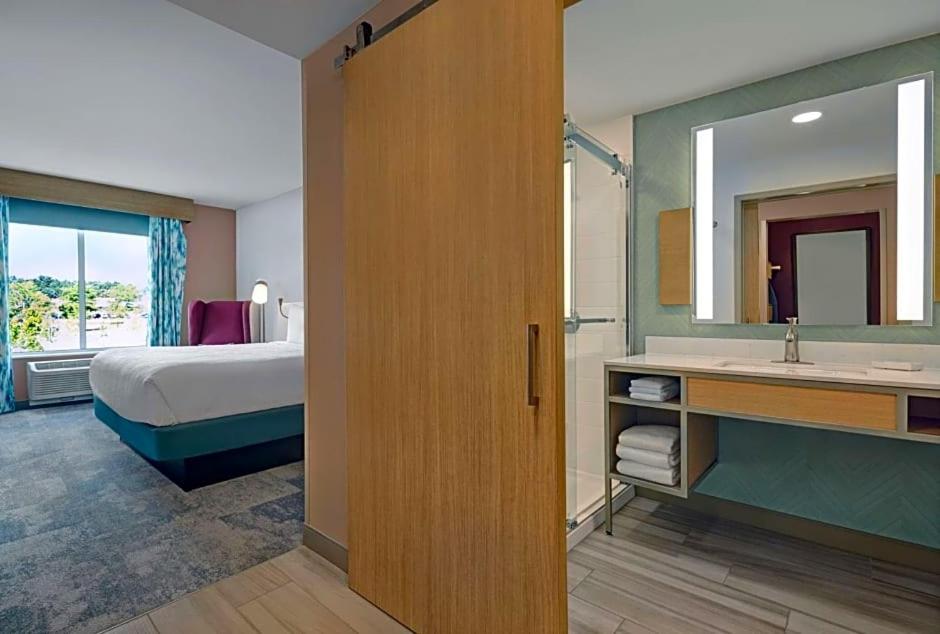 een hotelkamer met een bed en een badkamer met een wastafel bij Hilton Garden Inn in Manassas