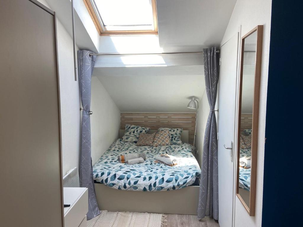 un lit dans une petite pièce avec une fenêtre dans l'établissement Studio Cosy Proche Centre Ville, à Villeurbanne