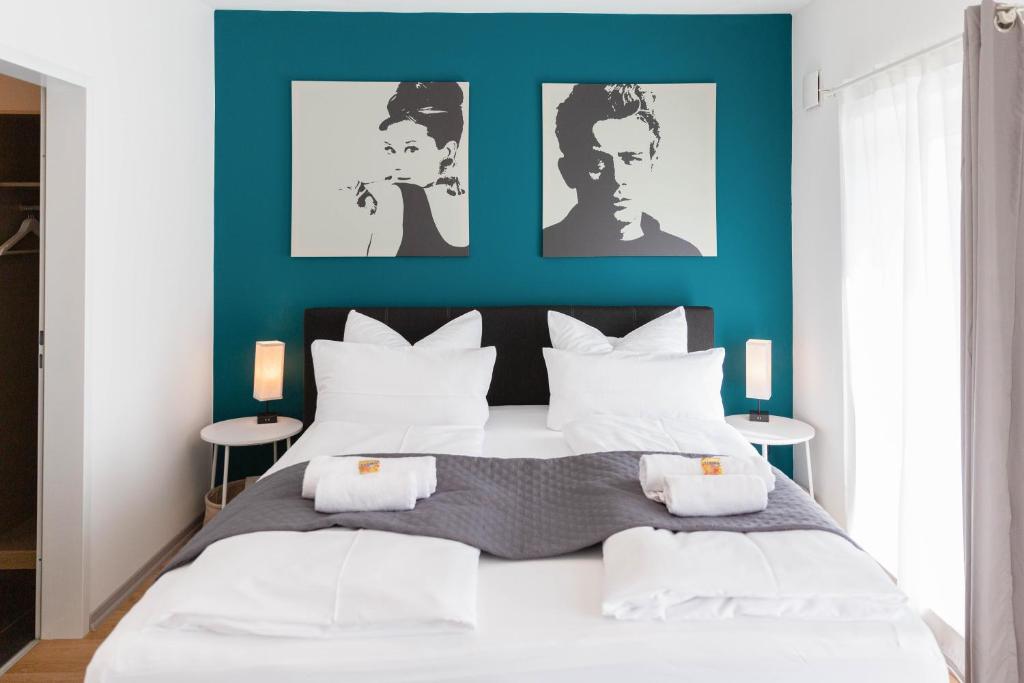 a bedroom with a bed with a blue wall at CABANA Kreyenbrück - Maisonette Apartments - Parkplatz - Nähe Klinikum - WLAN - Netflix in Oldenburg
