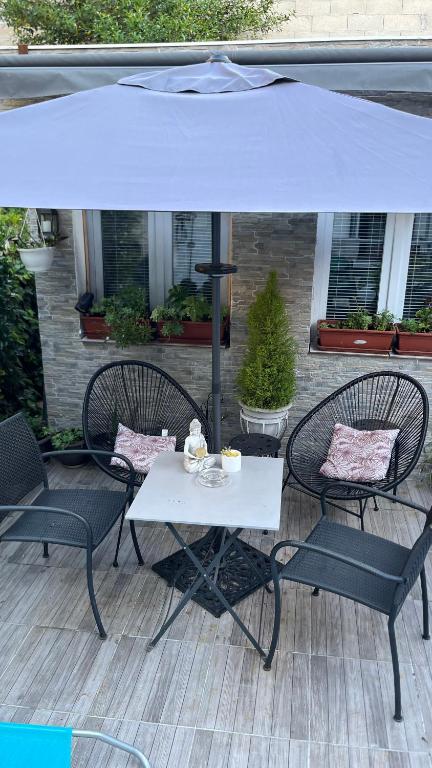 - une table et des chaises sous un parasol sur la terrasse dans l'établissement Adorable studio 20m2, à Aubervilliers