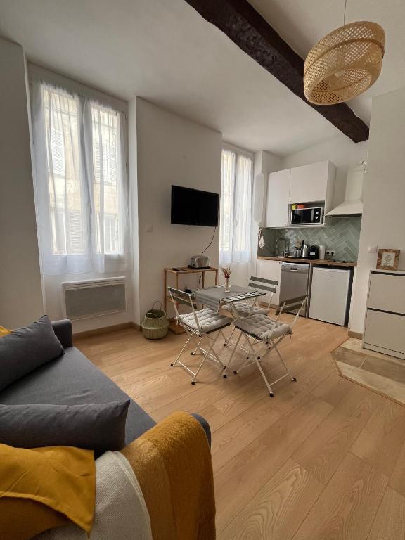 un salon avec une table et des chaises et une cuisine dans l'établissement Cosy et central - Cours Julien, à Marseille
