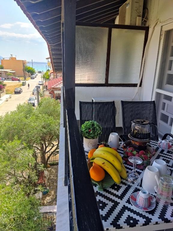 a table with bananas and fruit on a balcony at Katia's Apartments in Sarti