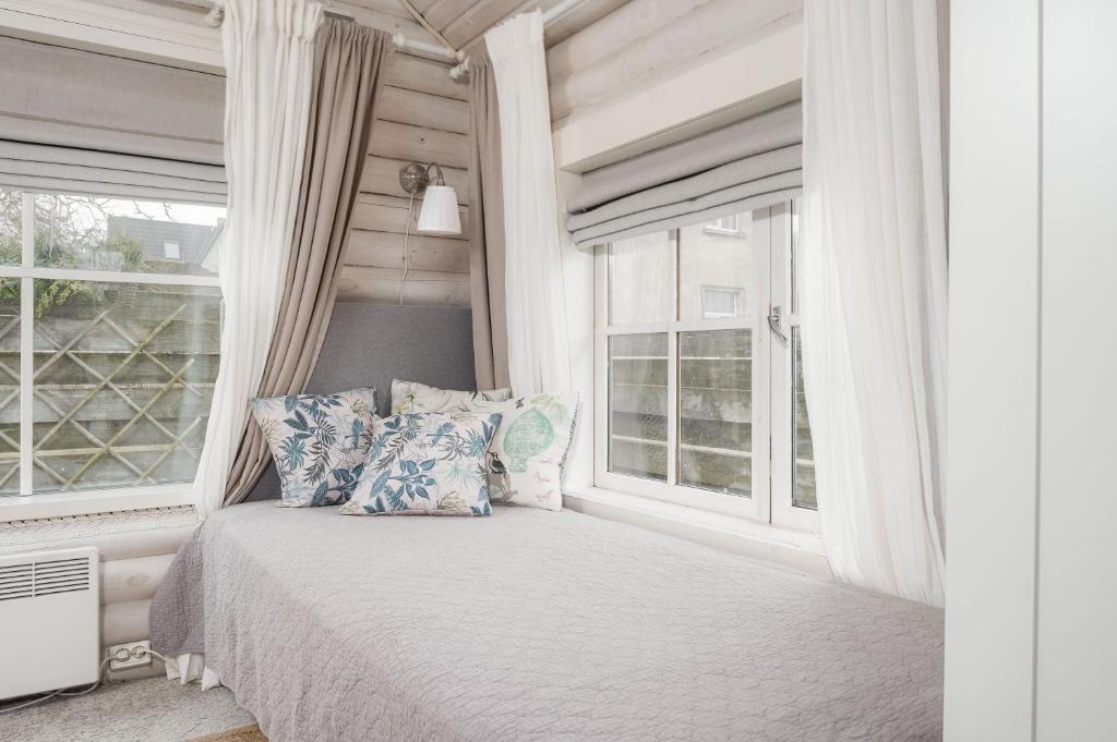 1 dormitorio con cama con almohadas y ventana en Guesthouse Delisa en Pärnu