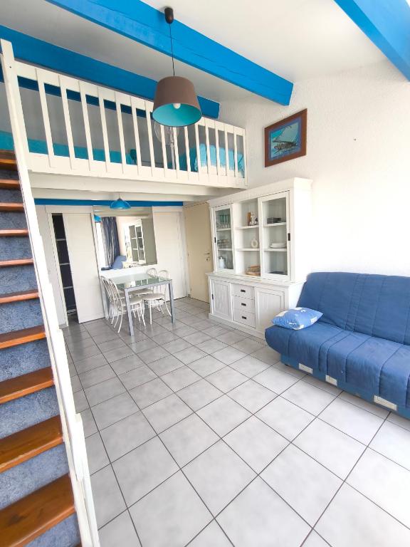 un salon avec un canapé bleu et une table dans l'établissement Appartement Port Barcarès Vue Marina, au Barcarès
