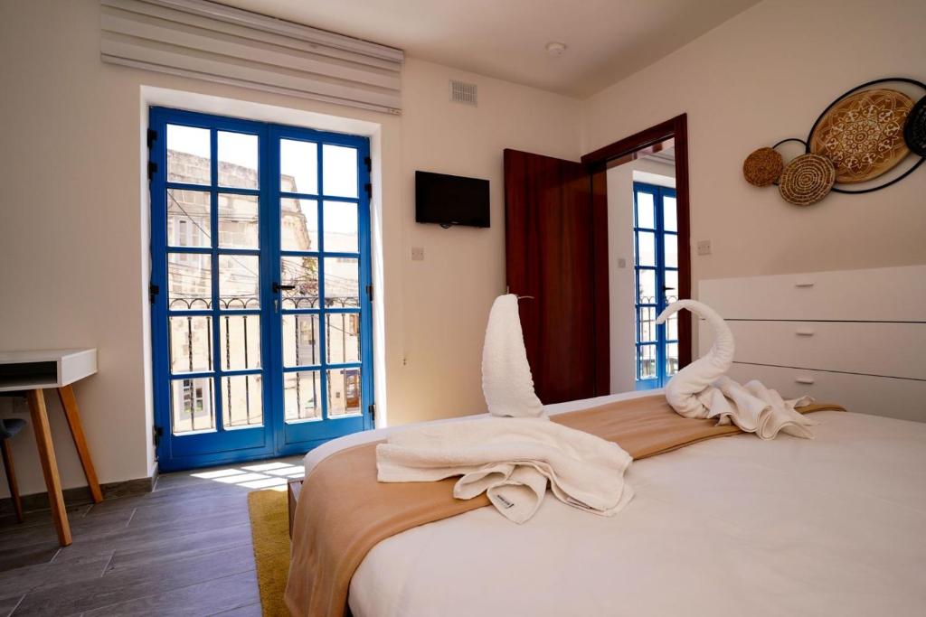 莫斯塔的住宿－Mosta Dome Penthouse，一间卧室配有带毛巾的床