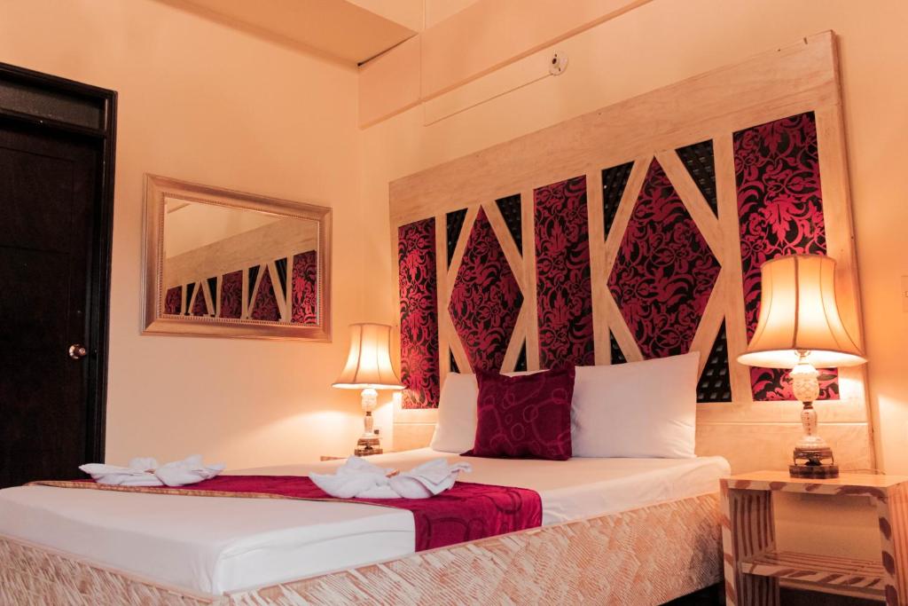 1 dormitorio con 2 camas y 2 lámparas en Hotel Plaza Garibaldi, en Caldas