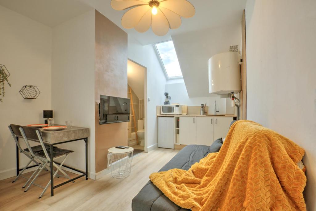 un salon avec un canapé et une table et une cuisine dans l'établissement Le Petit Hugo - Centre Ville - Parking, à Tarbes