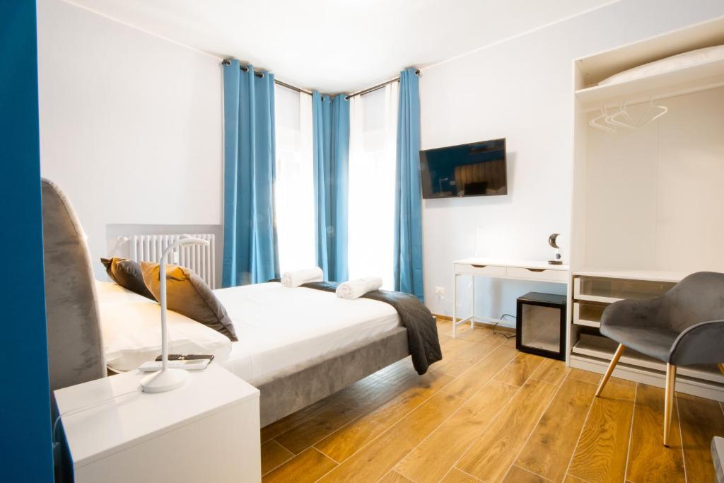 una camera da letto con letto con tende blu e scrivania di Arre Mida a Bari