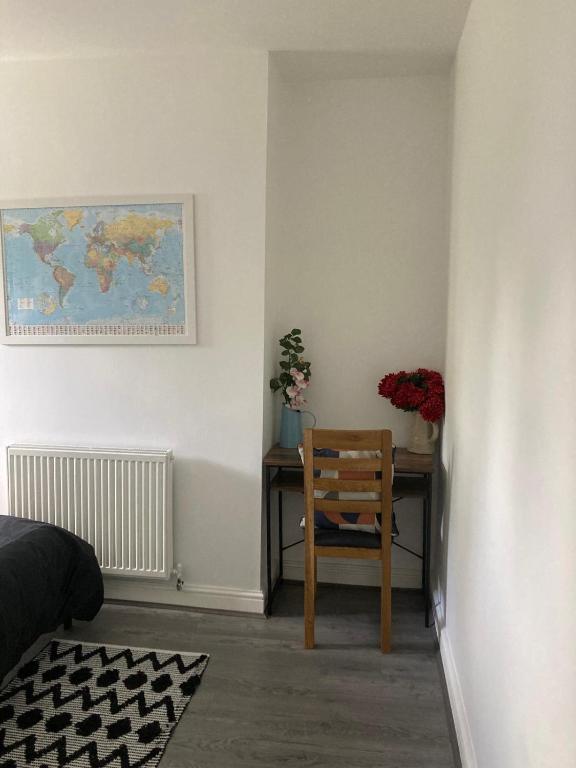 um quarto com uma secretária com uma cadeira e flores em Springhome Newport em Newport