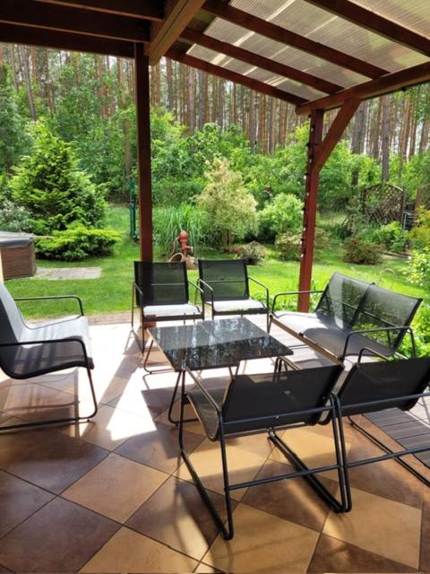 a group of chairs and a table on a patio at Dom wakacyjny MERLIN nad jeziorem Jodłów Sława Radzyń in Jodlow
