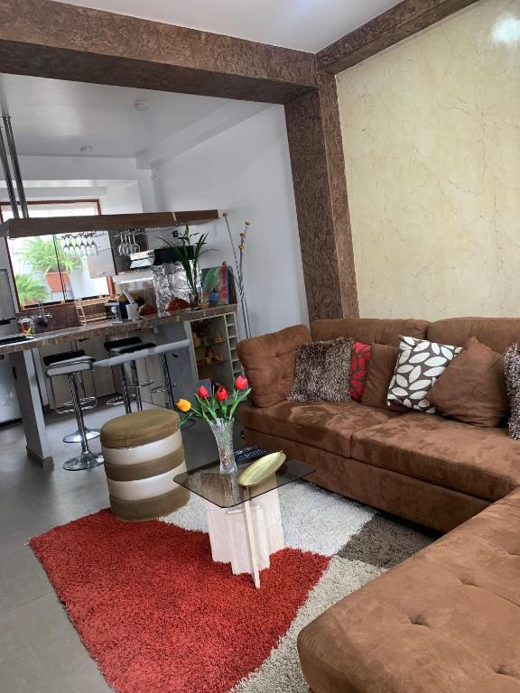 a living room with a brown couch and a table at Depa A-Primer Piso in Cajamarca
