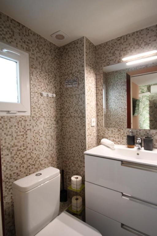 een badkamer met een toilet, een wastafel en een spiegel bij Pool Oasis with Mountain Views in Maçanet de la Selva