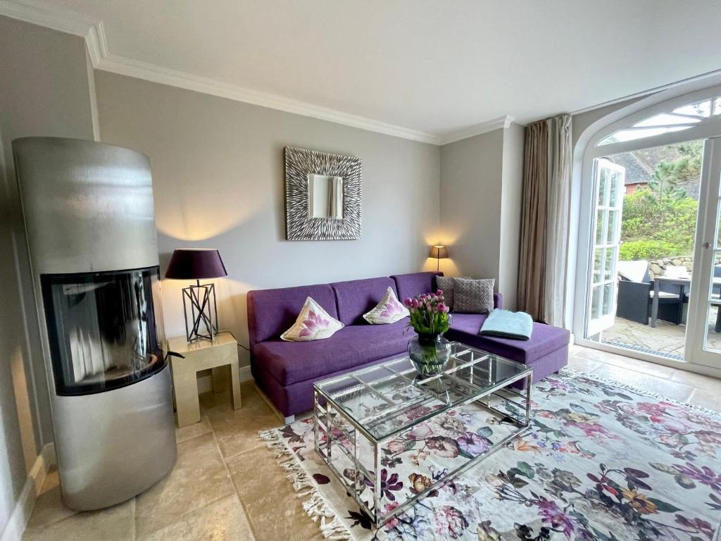 a living room with a purple couch and a fireplace at Beachhouse Seaside 3 in Rantum