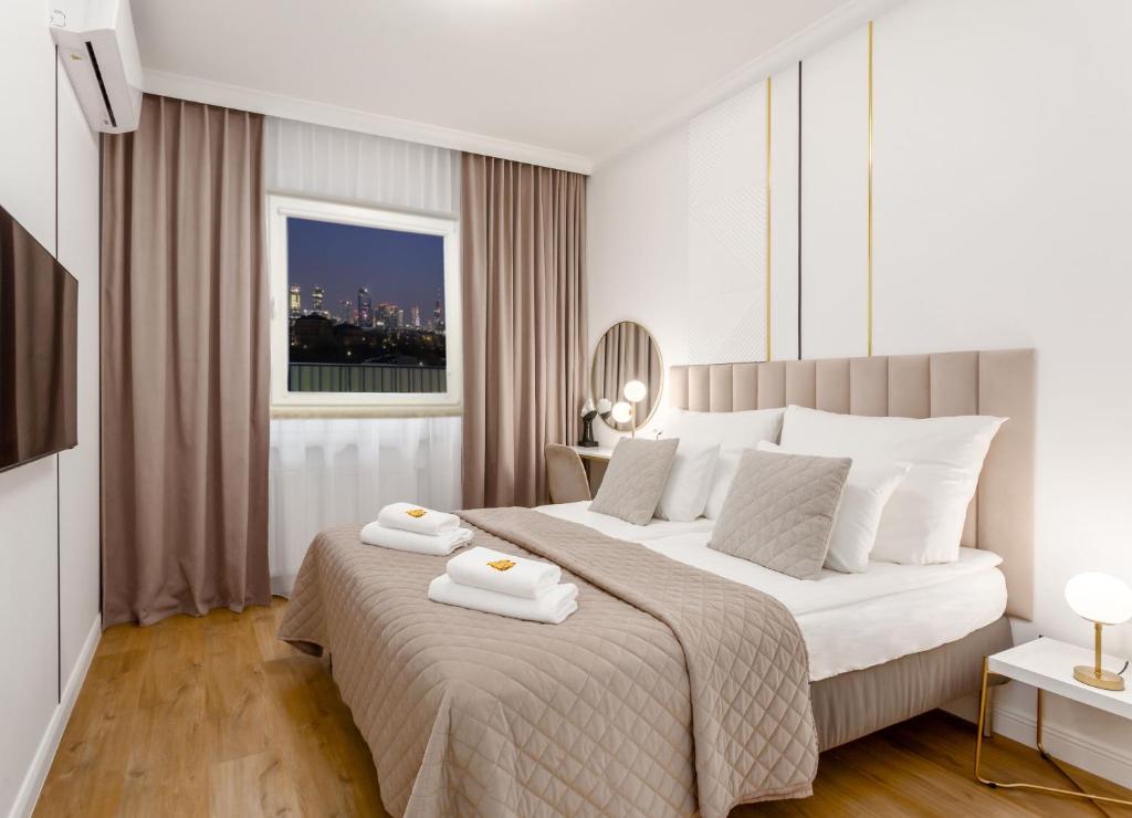 a bedroom with a large bed with two towels on it at Warsaw View Prestige Apartment in Warsaw
