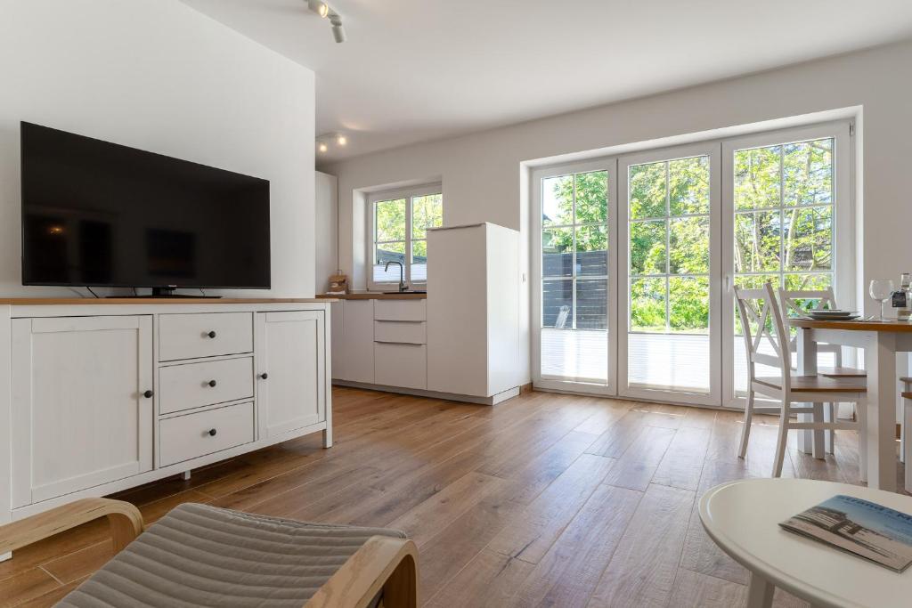 a living room with a flat screen tv on a white cabinet at Kleine Robbe in Böhl