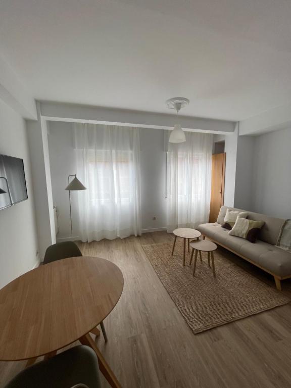 ein Wohnzimmer mit Sofa und Tisch in der Unterkunft Apartamento acogedor en el centro de Cangas in Cangas