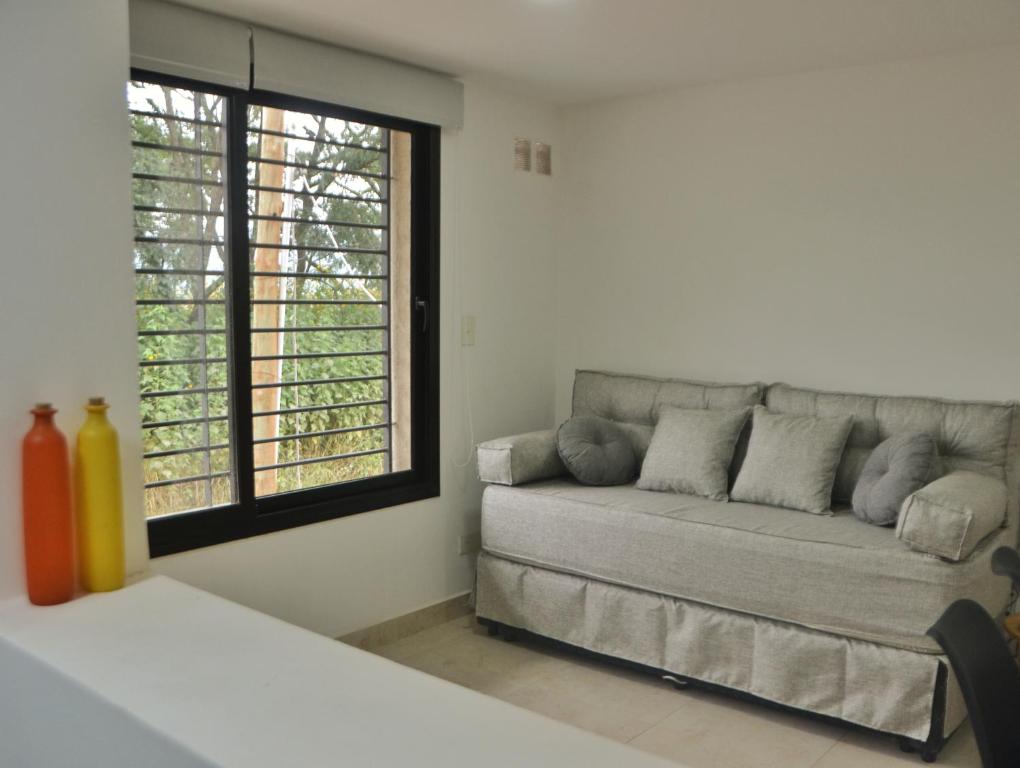 Una sala de estar con un sofá y una ventana. en Departamento entero Mirador de Jujuy, en San Salvador de Jujuy