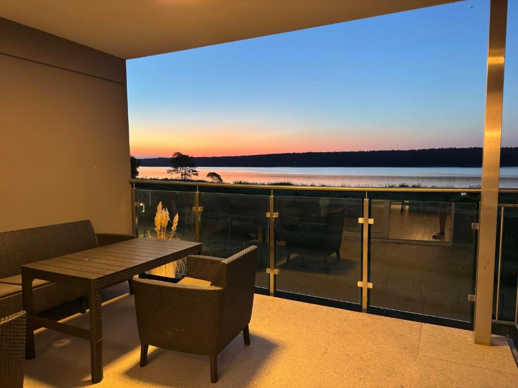 a balcony with a table and chairs and a view of the ocean at Apartament Pod Żaglami in Zegrze Południowe