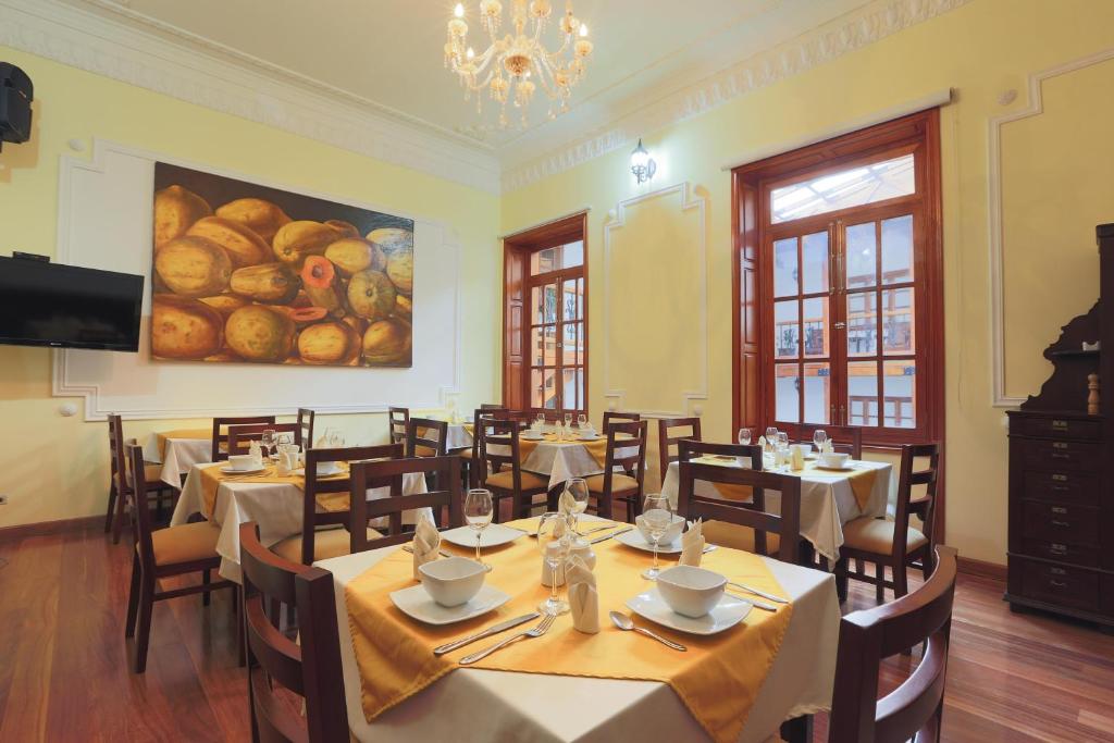 een restaurant met tafels en stoelen en een schilderij aan de muur bij HOSPEDAJE BOGOTA CENTRO in Bogota