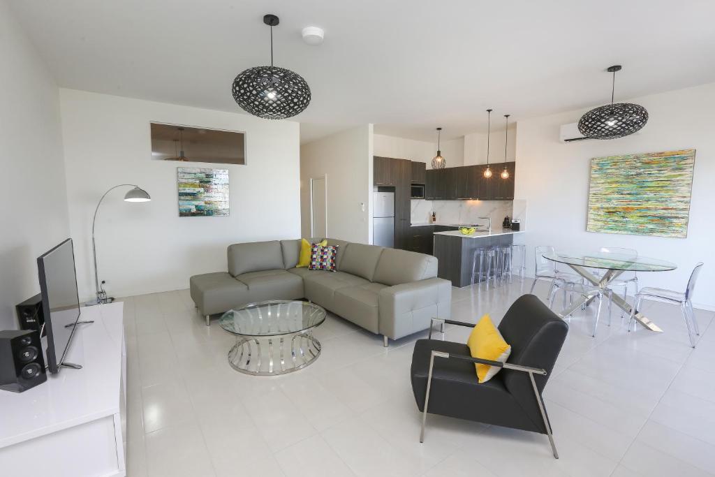 a living room with a couch and a table at Indulge Apartments - CBD in Mildura