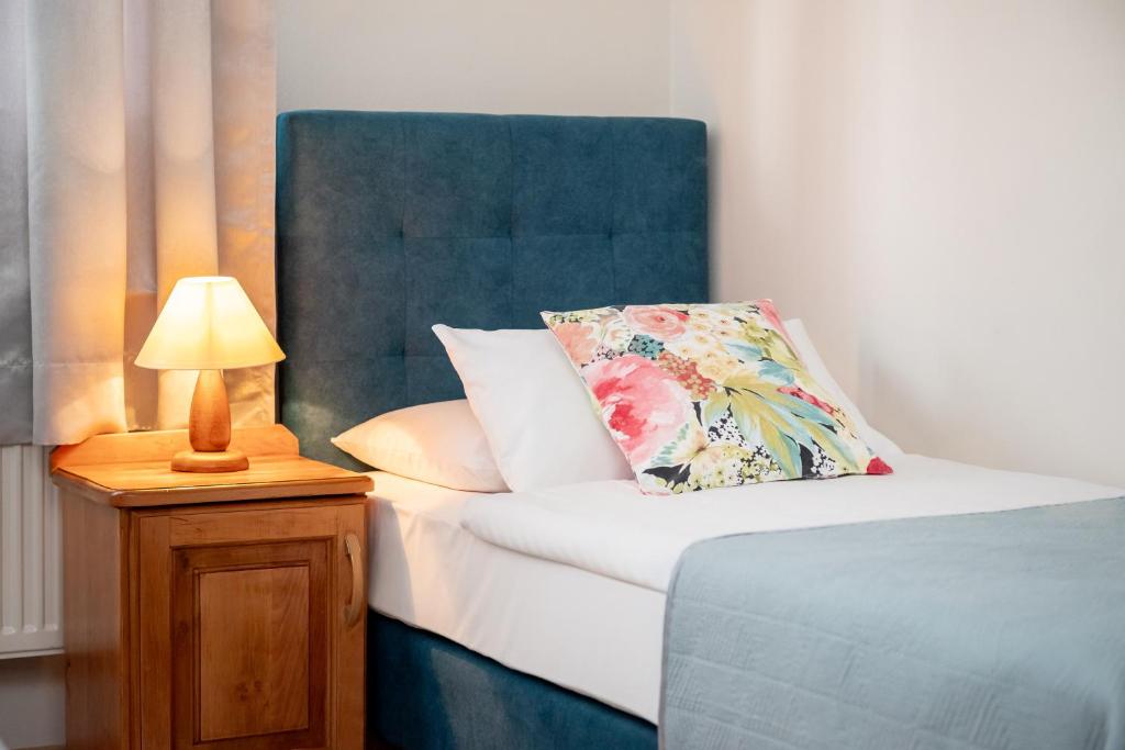 a bed with a pillow and a lamp on a night stand at WILLA ANNA - 20 procent Termy Gorący Potok in Szaflary