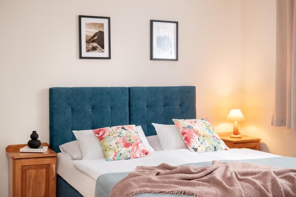 a bedroom with two beds with a blue headboard and pillows at WILLA ANNA - 20 procent Termy Gorący Potok in Szaflary