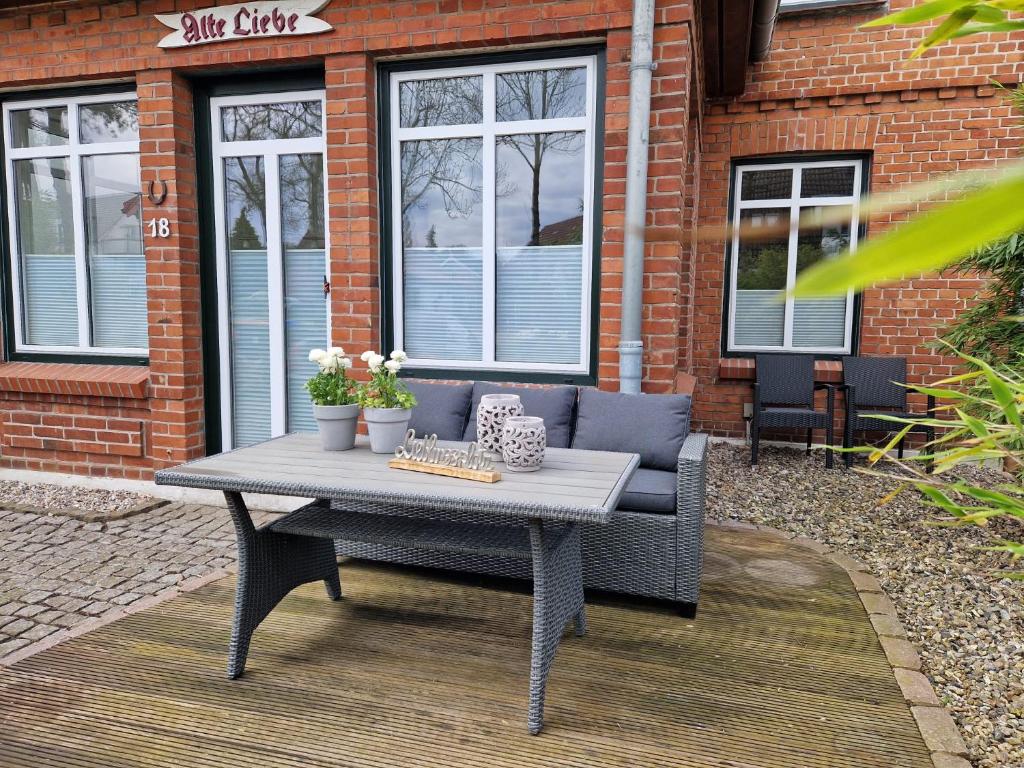 een tafel en een bank op een patio bij AMW18 Ferienwohnung Alte Liebe in Häven