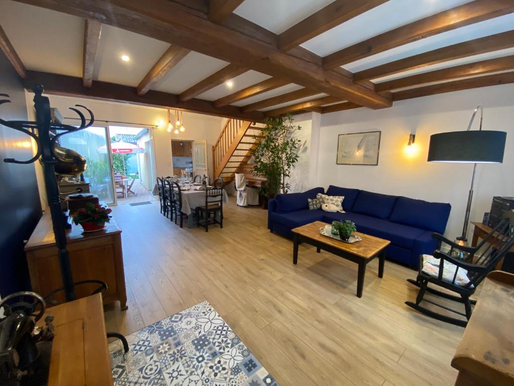 un salon avec un canapé bleu et une table dans l'établissement La maison des vacances chez Geneviève & Norbert 6 à 8 personnes, à Les Sables-dʼOlonne